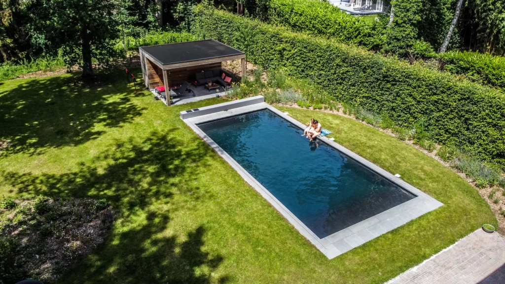Pool with a coverseal. 2 kids are on sitting on the side of the pool