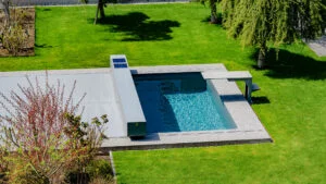 A sliding deck can help compact backyards serve as both a pool and an outdoor living area.